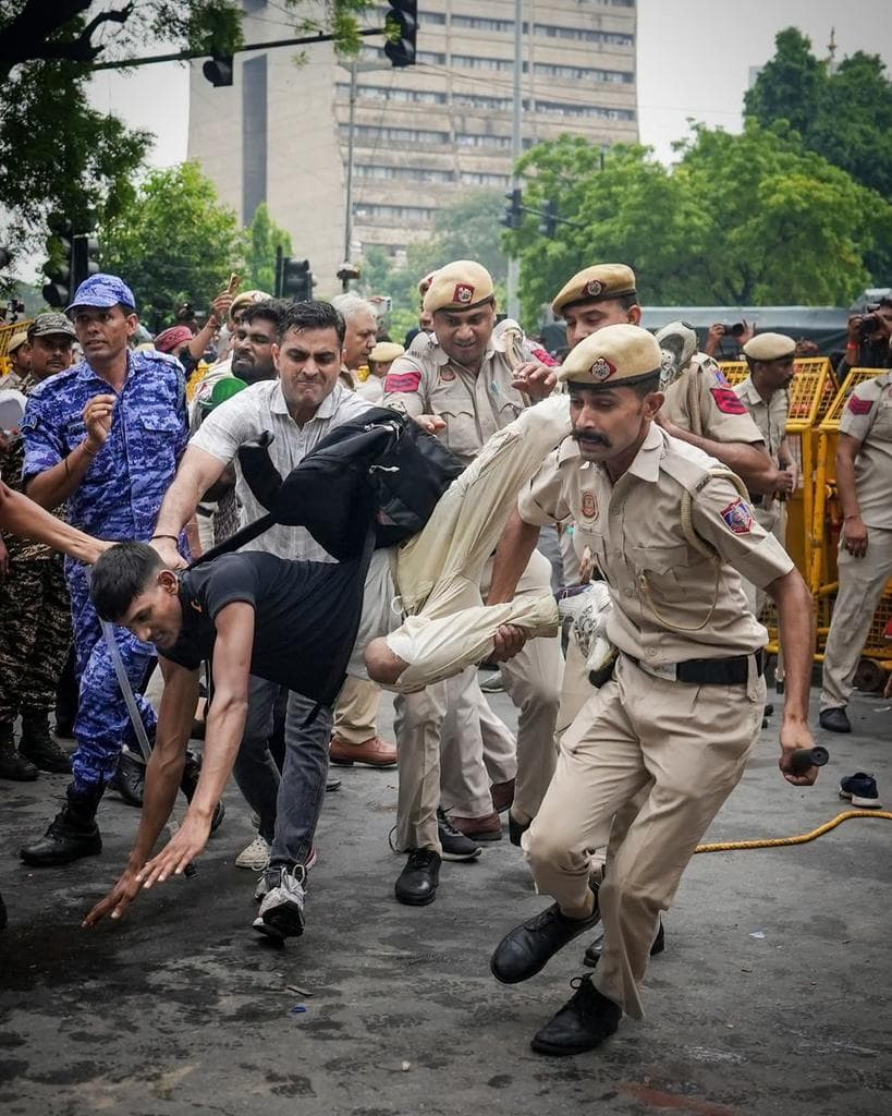 Delhi Police officers detaining a student protester
