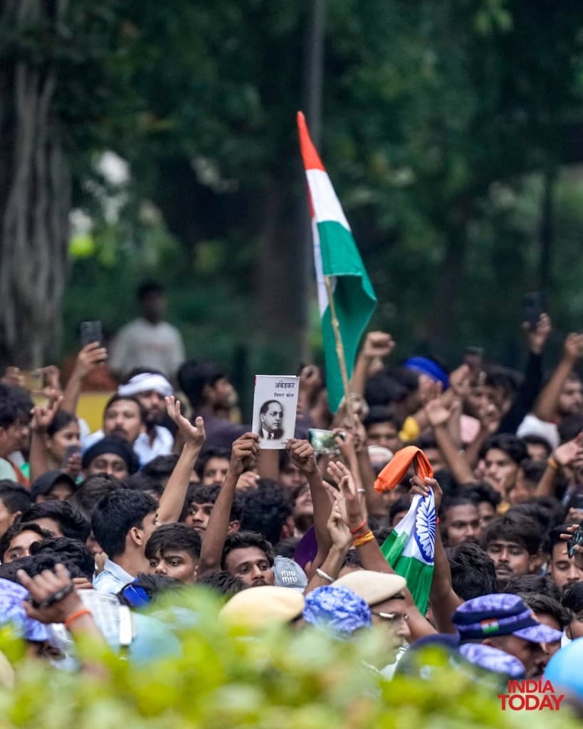 Protest crowd holding Ambedkar portrait and Indian national flag